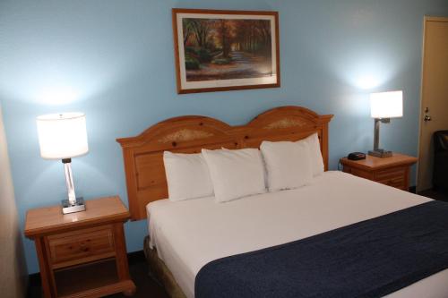 a bedroom with a bed with two nightstands and two lamps at Baymont by Wyndham Yakima Riverfront in Yakima