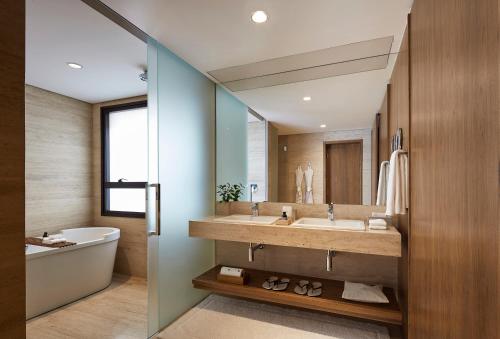 a bathroom with a sink and a tub and a mirror at Hotel Fasano Belo Horizonte in Belo Horizonte