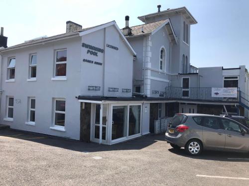 a car parked in a parking lot in front of a building at The Purple Tree Guest House in Torquay