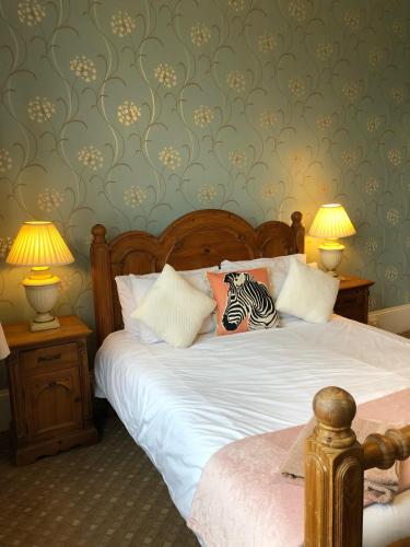 a bedroom with a bed with two lamps and a zebra pillow at The Purple Tree Guest House in Torquay