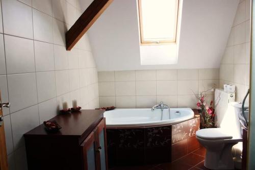 a bathroom with a tub and a toilet at Agroturystyka Rębowo in Kłodawa