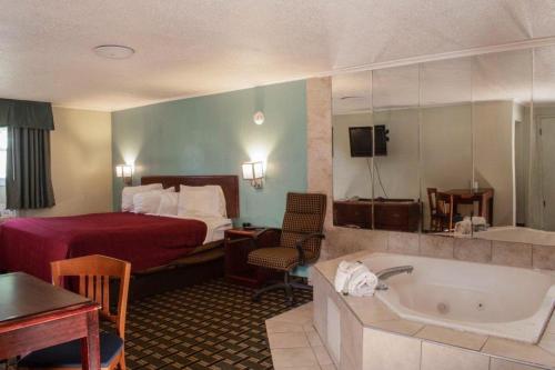 um quarto de hotel com uma cama e uma banheira em Boulevard Inn em Amherst