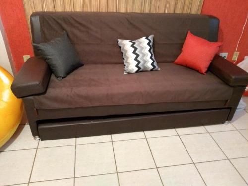 a brown couch with pillows on it in a room at Cond. Golden Thermas Residence - Shapphire Tower in Caldas Novas