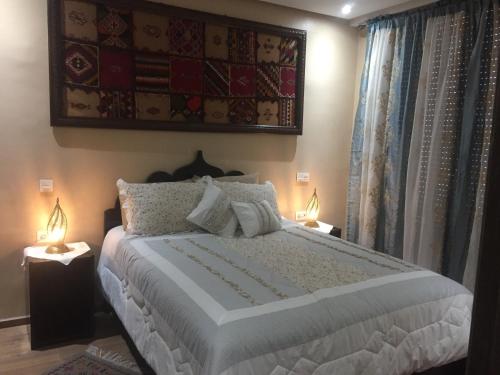 una camera con un grande letto con due lampade di B-LBAIT Agadir Morning light for Family ad Agadir
