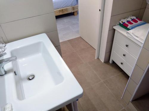 a bathroom with a white sink and a bed at La Calata in Portovenere