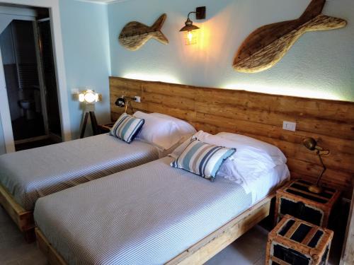 2 Betten in einem Hotelzimmer mit Fisch an der Wand in der Unterkunft La Calata in Porto Venere