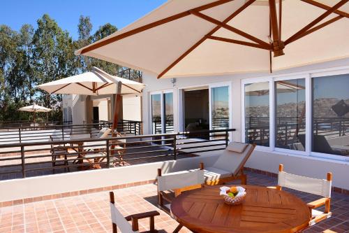 a patio with a table and chairs and umbrellas at DM Hoteles Moquegua in Moquegua