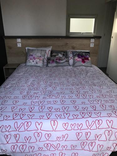a large bed with a purple blanket and pillows at L Orée Du Bois in Moncheux