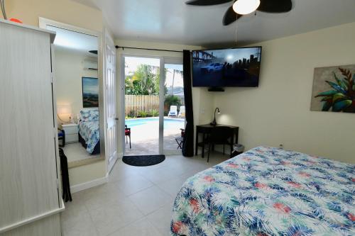 a bedroom with a bed and a flat screen tv at Fantasy Island Inn, Caters to Men in Fort Lauderdale