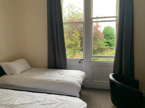 a room with a bed and a window and a chair at Mayfair Guest House in Edinburgh