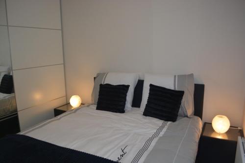 a bedroom with a bed with two black pillows at Residentie Capri in Middelkerke