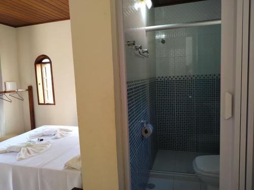 a bathroom with a shower and a toilet at Estalagem São Gonçalo in Tarituba