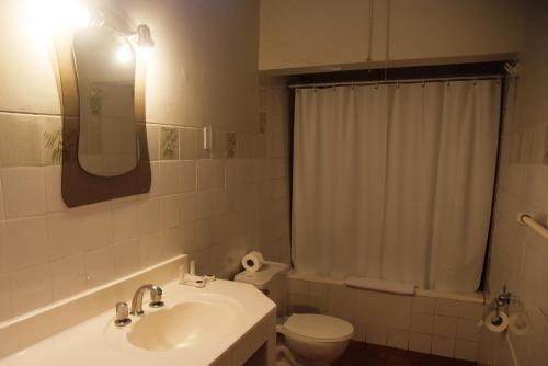 a bathroom with a toilet, sink, and mirror at DM Hoteles Mossone - Ica in Ica