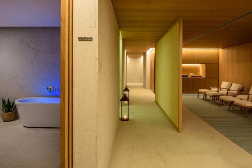 a hallway leading to a bathroom with a tub at Hotel Fasano Angra dos Reis in Angra dos Reis