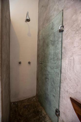 a shower with a glass door in a bathroom at Casa Love in Sayulita
