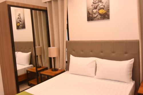 a hotel room with a bed and a mirror at Andeo Suites in Angeles