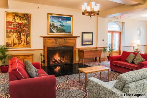 a living room with red furniture and a fireplace at Hotel Tadoussac in Tadoussac