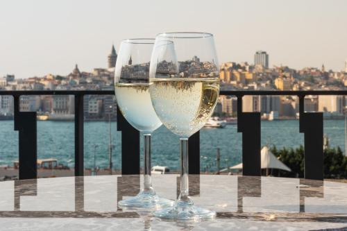 a glass of wine sitting on a pier next to a body of water at MEG HOTEL in Istanbul