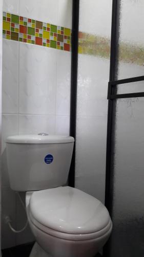 a bathroom with a white toilet in a stall at Hostal Casa de Los Taitas in Salento