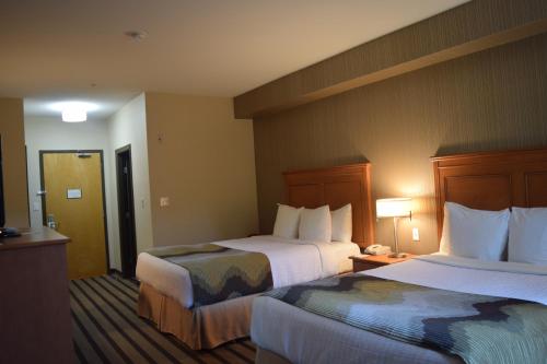 a hotel room with two beds and a television at Best Western King George Inn & Suites in Surrey