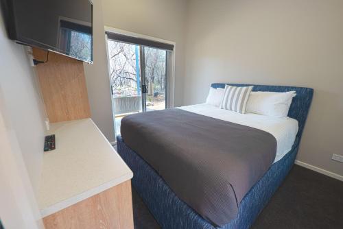 a bedroom with a bed and a window at NRMA Tathra Beachfront Holiday Park in Tathra