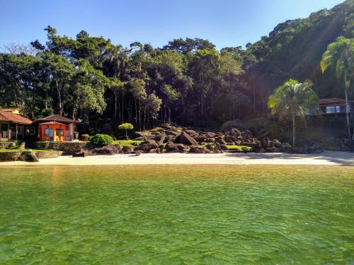 a view of a beach with a house and trees at Vale do Pontal Angra Suites in Angra dos Reis