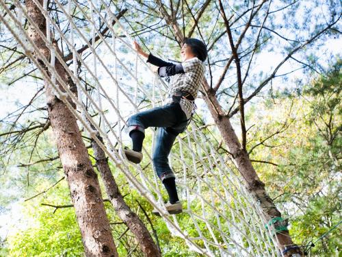 a woman is climbing a tree at Hotel Epinard Nasu in Nasu