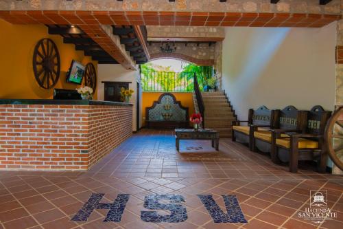 a living room with couches and a brick wall at Hacienda San Vicente in Flores