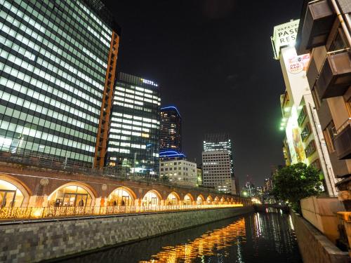 a river in a city at night with buildings at Super Hotel Premier Akihabara in Tokyo