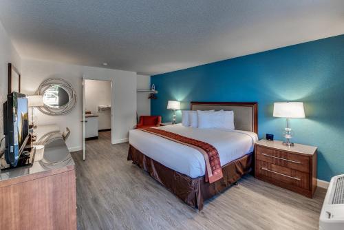 a hotel room with a large bed and a television at Angels Inn in Angels Camp