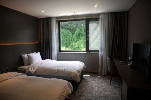 Tempat tidur dalam kamar di Mudeung Park Hotel