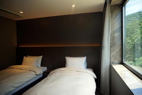Ένα ή περισσότερα κρεβάτια σε δωμάτιο στο Mudeung Park Hotel