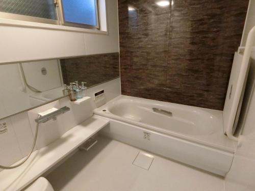 a bathroom with a tub and a toilet and a sink at 宿坊 正伝寺 Temple hotel Shoden-ji in Tokyo
