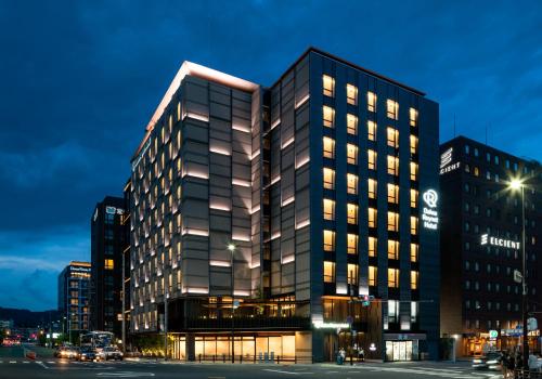 a lit up building in a city at night at Daiwa Roynet Hotel Kyoto Terrace Hachijo PREMIER in Kyoto