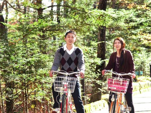a man and a woman riding bikes down a path at Hotel Epinard Nasu in Nasu