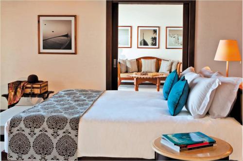 a hotel room with a large bed with blue pillows at The Residence Maldives in Gaafu Alifu Atoll