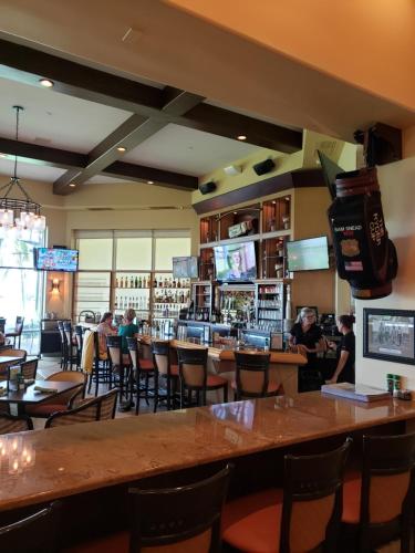 a restaurant with tables and chairs and a bar at Vacation in Paradise in Lely Resort
