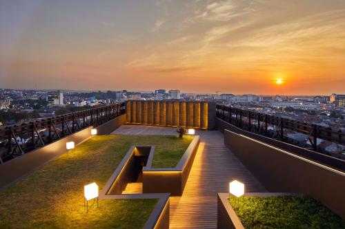 a balcony with a view of the city at sunset at ARTOTEL Gajahmada Semarang in Semarang