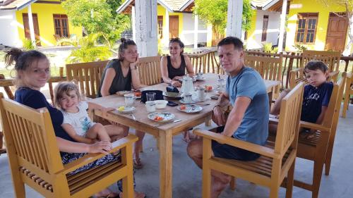 um grupo de pessoas sentadas em torno de uma mesa de madeira em Exotic Beach Hotel em Arugam Bay