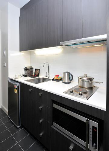a kitchen with two pots and a sink and a stove at Mercure Melbourne Therry Street in Melbourne