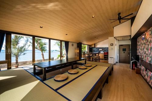 a living room with a table and a dining room at The Peridot Smart Hotel Tancha Ward in Onna