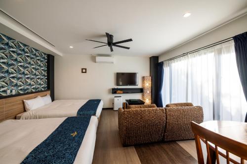 恩納村にあるザ・ペリドット スマートホテル タンチャワードのベッド2台とテーブルが備わるホテルルームです。