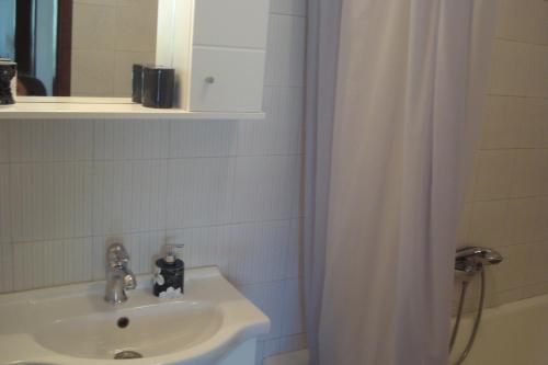 a bathroom with a sink and a shower curtain at Apartments Vidakovic in Ugljan