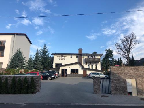 a building with cars parked in a parking lot at Penzion Panorama in Liptovský Mikuláš