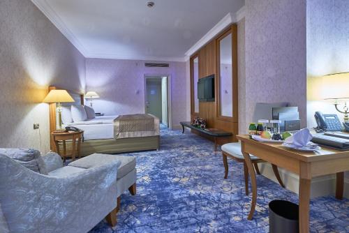 a hotel room with a bed and a desk at Rixos President Hotel Astana in Astana
