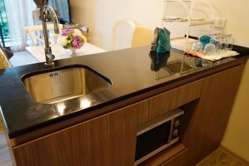 a kitchen counter with a sink and a microwave at Rain condo ChaAm HuaHin by AY B311 in Cha Am