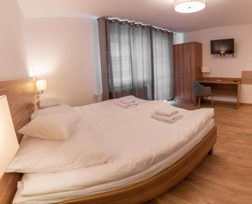 1 cama blanca grande en una habitación con escritorio en Apartamenty ZYGFRYD 28C/3/1, en Bystrzyca Kłodzka