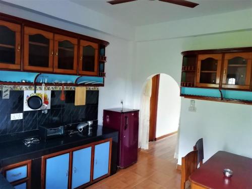 a kitchen with wooden cabinets and a table at Pokhara Star Inn Pvt Ltd in Pokhara