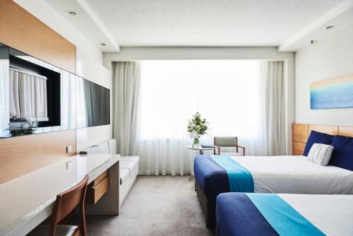 a hotel room with two beds and a tv at The Ville Resort - Casino in Townsville