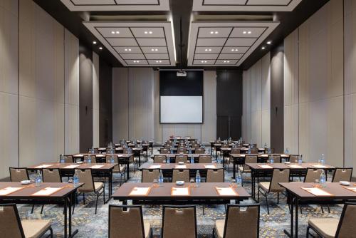 a conference room with tables and chairs and a screen at Avani Sukhumvit Bangkok Hotel in Bangkok